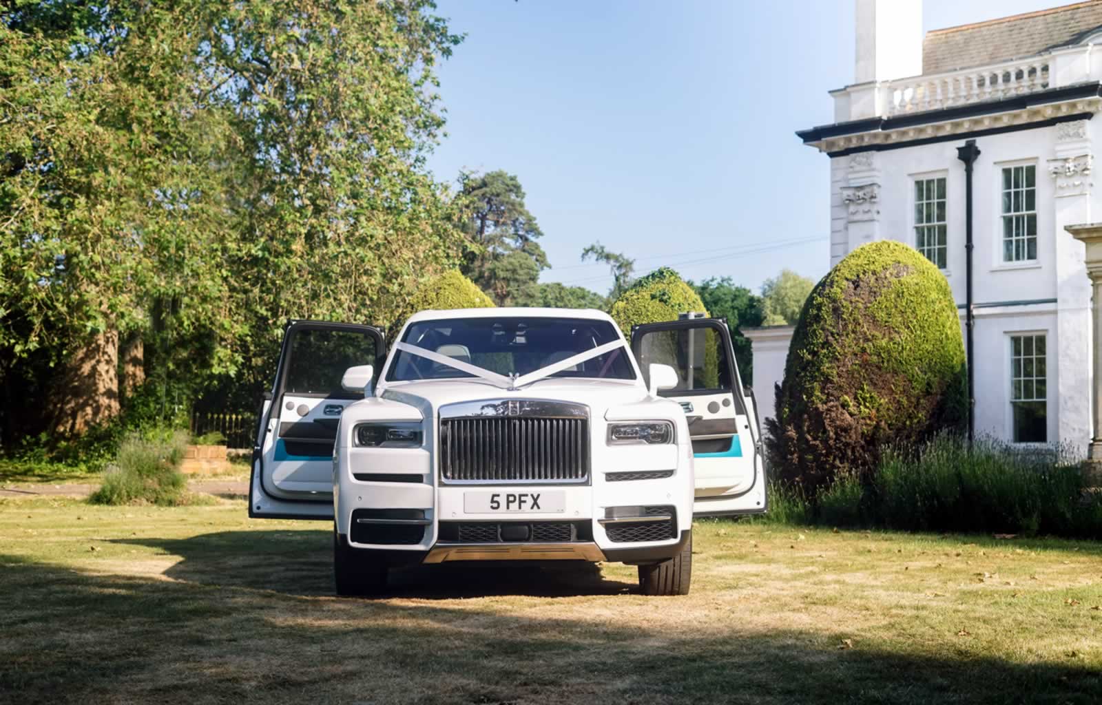 Rolls-Royce Cullinan with rear coach doors open and wedding car ribbons decoration
