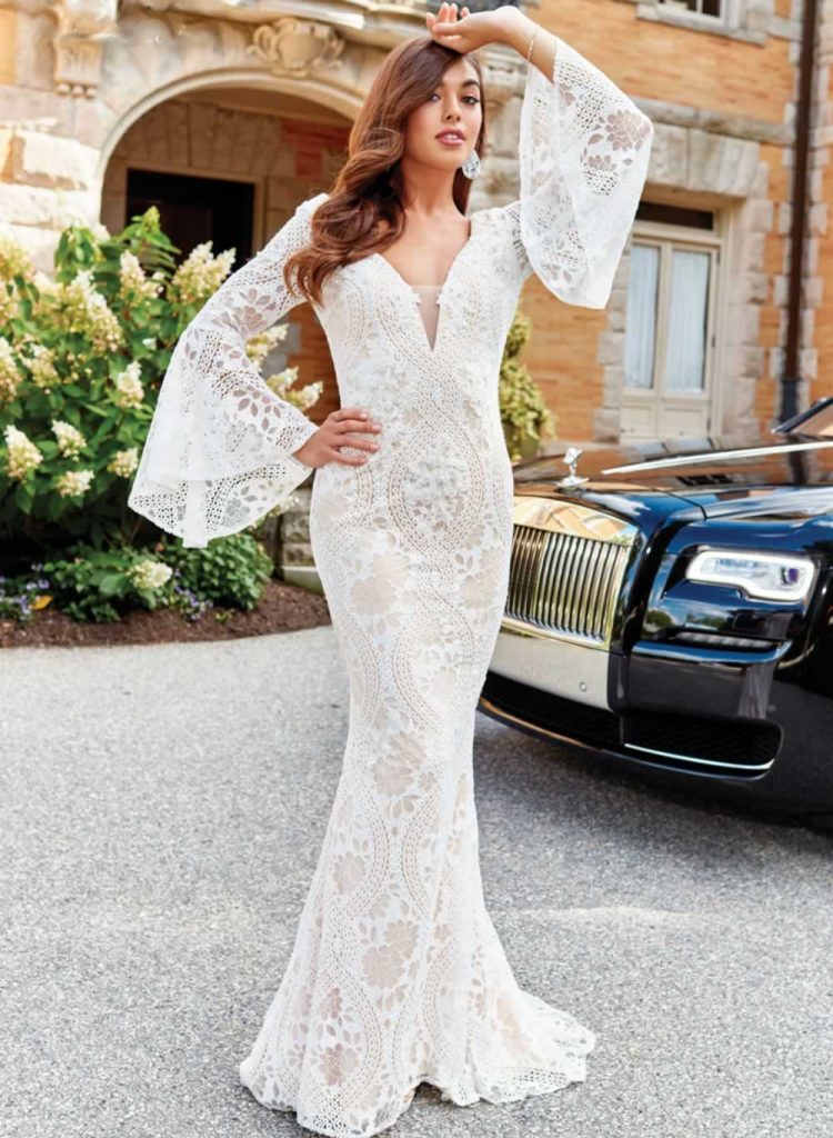 Bride wearing a column silhouette wedding dressstanding beside a black Rolls-Royce wedidng car
